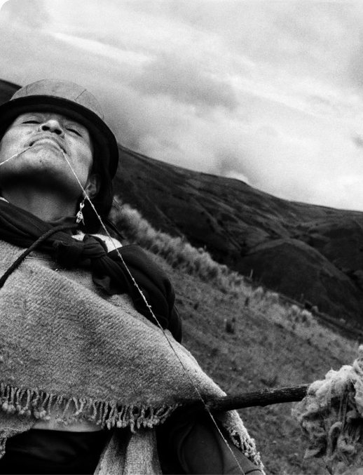 Woman in a poncho looking to the sky on a mountainside